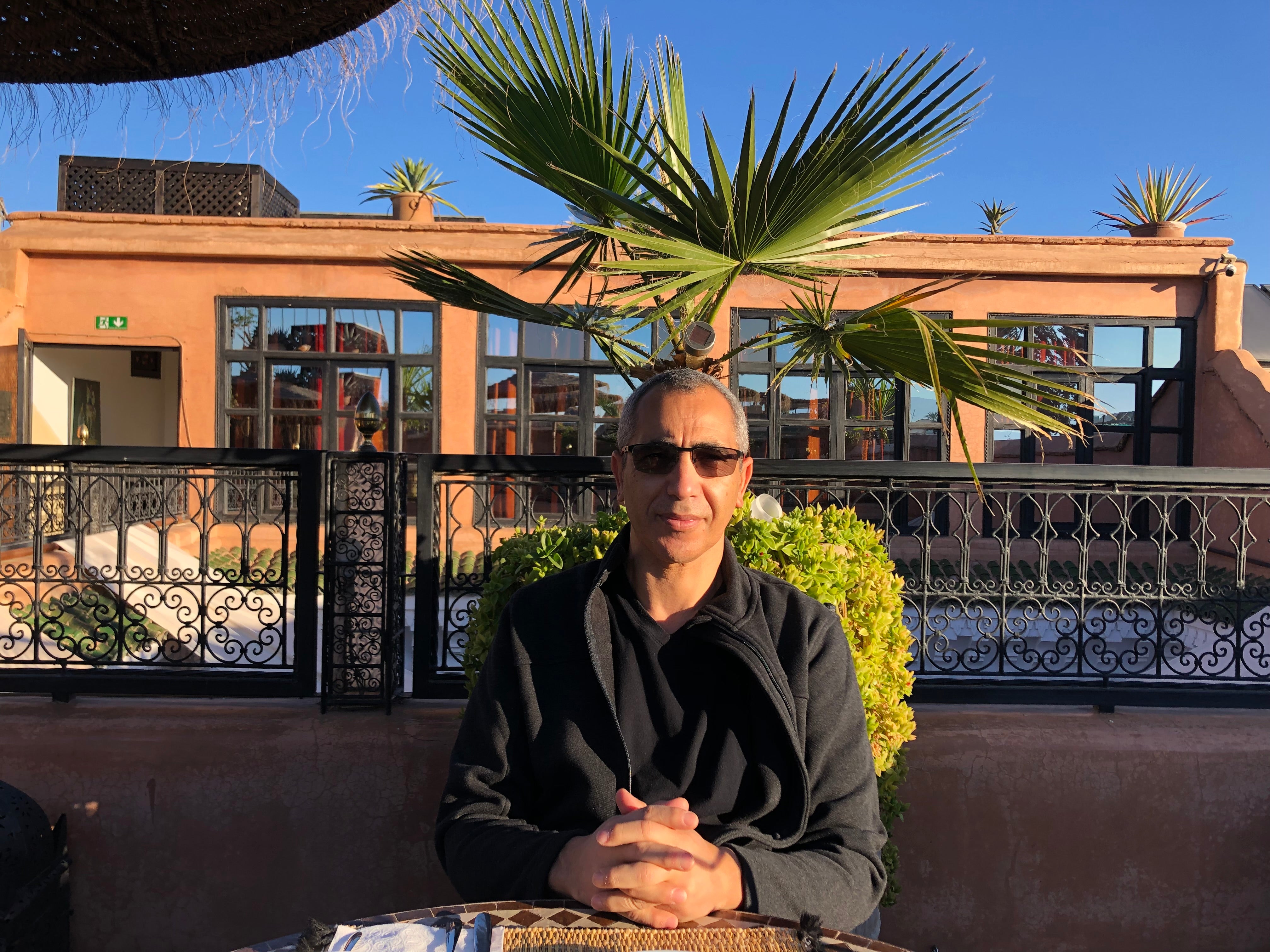 Portrait d’Aziz El Kihel, fondateur de DrinkWell, assis en extérieur au soleil. Représente les valeurs d’engagement, de stabilité et de durabilité portées par la marque.